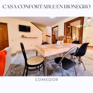 里奧內格羅的住宿－Casa Confortable en Rionegro - a 10 min del aeropuerto，一间带木桌和椅子的用餐室