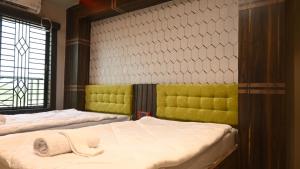 1 dormitorio con 2 camas y ventana en Hotel Maisha International, en Sonāmura