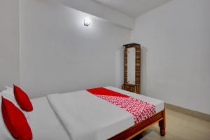 a bedroom with a bed with red and white sheets at OYO Flagship Larica Green Valley in Guwahati