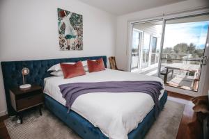 a bedroom with a large bed and a large window at 12 Apostles Accommodation Anchors Beach House with sea views in Port Campbell