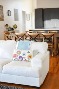 un sofá blanco en una sala de estar con cocina en 12 Apostles Accommodation Anchors Beach House with sea views, en Port Campbell