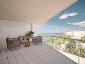 a balcony with chairs and a view of the ocean at Ardo in Townsville