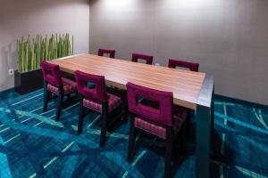 a conference room with a wooden table and purple chairs at SpringHill Suites by Marriott Greensboro in Greensboro