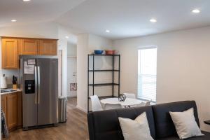 cocina y sala de estar con sofá y nevera. en Modern 2-Bedroom Eucalyptus House, en San Luis Obispo