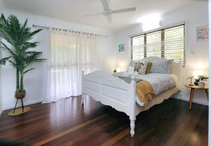 ein Schlafzimmer mit einem weißen Bett und einem Fenster in der Unterkunft 34 Corser Street Burnett Heads in Bargara
