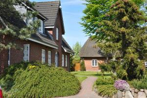 a brick house with a walkway in front of it at Inselhotel Arfsten in Wyk auf Föhr