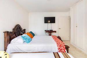 um quarto com duas camas e uma televisão na parede em Hermoso Apartamento Riomar em Barranquilla