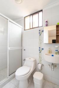 Hermoso Apartamento Riomar في بارانكويلا: حمام ابيض مع مرحاض ومغسلة