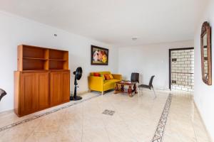 Hermoso Apartamento Riomar في بارانكويلا: غرفة معيشة مع أريكة صفراء وطاولة
