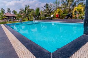 een zwembad in een resort met blauw water bij Abhishta Agri Farm Stay in Kunigal