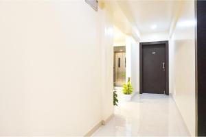 a hallway with a black door and a plant at FabHotel Majestic Luxurious in Pune