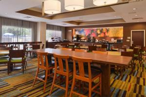 uma sala de jantar com uma grande mesa de madeira e cadeiras em Fairfield Inn Orlando Airport em Orlando