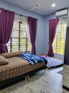 a bedroom with purple curtains and a bed and windows at Homestay Umar in Bachok