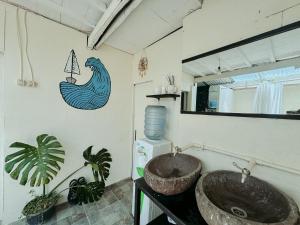 baño con lavabo y un pez en la pared en De Nata en Labuan Bajo