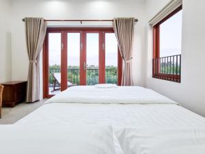 a bedroom with a bed and a large window at Sông Mê Home in Vĩnh Long