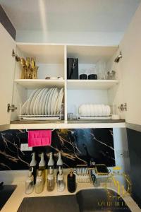 a kitchen with white shelves and bottles of wine at Azure Urban Resort near NAIA Airport in Manila