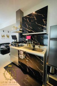a kitchen with a counter with a sink and a stove at Azure Urban Resort near NAIA Airport in Manila