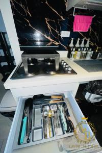 a drawer in a refrigerator filled with utensils at Azure Urban Resort near NAIA Airport in Manila