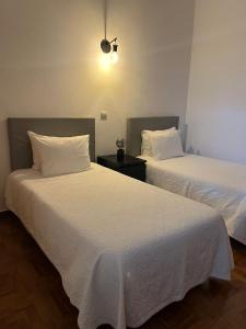 twee bedden naast elkaar in een kamer bij Romeu in Quarteira
