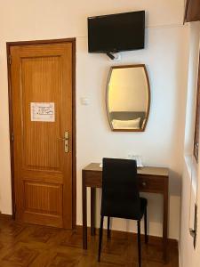 Pokój z biurkiem, lustrem i drzwiami w obiekcie Romeu w mieście Quarteira