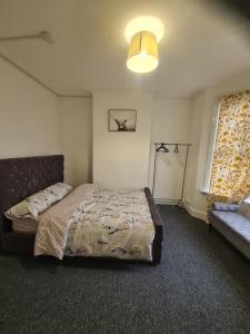 um quarto com uma cama, uma janela e um sofá em Contractors Accommodation in Gillingham - Ideal for long and short stay em Gillingham