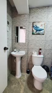 a bathroom with a toilet and a sink at Sanbar House in San Bartolo +7 photos