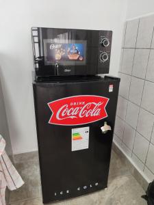 a cocacola machine with a television on top of it at Sanbar House in San Bartolo