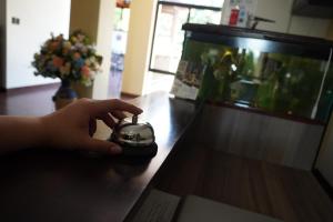 une main tenant une horloge assise sur une table dans l'établissement Villa Las Flores, à San Salvador