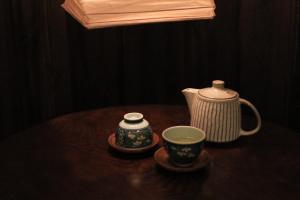 すずめや築地 في طوكيو: طاولة مع وعاء الشاي وأكواب عليها