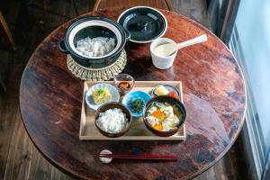 una mesa de madera con tazones de comida. en すずめや築地 en Tokio