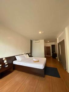 Schlafzimmer mit einem großen weißen Bett und Holzböden in der Unterkunft Ananyana Leisure Beach Resort in Panglao