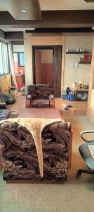 una sala de estar con una mesa hecha de troncos en 1bhk en Pātan