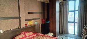 una camera con un letto e una grande finestra di 1bhk a Patan