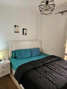 sypialnia z łóżkiem z niebieską pościelą i szafką nocną w obiekcie شقة مفروشةومريحةفي مدينتي قريبة من كل الخدمات والحركة w mieście Madinaty