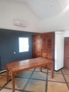 einen Holztisch in einem Zimmer mit Fenster in der Unterkunft Maison jaune bord de la mer in Ambatoloaka