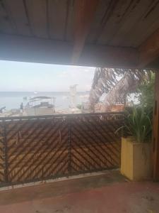 a wooden fence with a view of the ocean at Maison jaune bord de la mer in Ambatoloaka