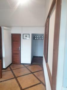 einen Flur eines leeren Zimmers mit zwei Türen in der Unterkunft Maison jaune bord de la mer in Ambatoloaka