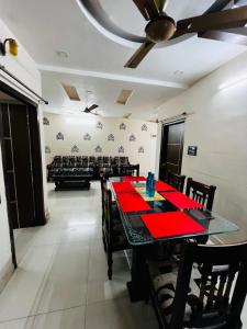 a dining room with a red table and chairs at Crystal dew in Visakhapatnam