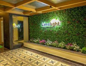 una tienda de manzanas con una pared verde con flores en Hotel Limelight, en Kudāl