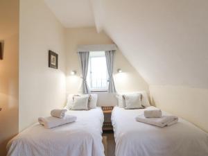 two twin beds in a room with a window at Cowfair Cottage in Chipping Campden