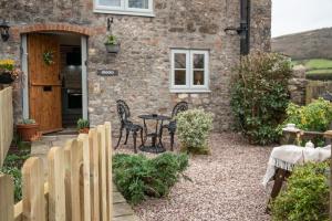 a stone house with a table and chairs in front of it at Crooks in Axbridge