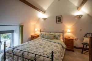 a bedroom with a bed and two lamps and a window at Crooks in Axbridge