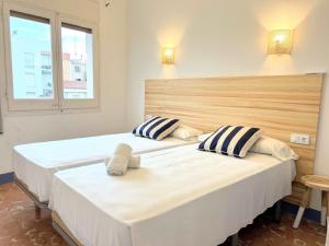 two beds in a room with two windows at Hotel Casa Mas in Lloret de Mar