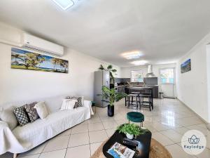 a living room with a white couch and a kitchen at Rayon de Soleil - maison T3 - 3 étoiles - Saint-Louis in Saint-Louis