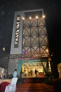a person standing in front of a building at night at Hotel Taj Akash in Deoghar