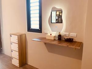 a dressing room with a shelf and a mirror at Dreamy Nomads Hostel日月潭背包客 in Yuchi