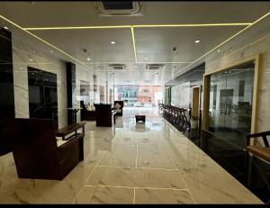 Cette grande chambre comprend un hall avec une table et des chaises. dans l'établissement Hotel Taj Akash, à Deoghar