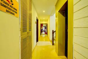 un pasillo con paredes amarillas y un pasillo largo en Super OYO Hotel Sunshin Deluxe, en Nagpur