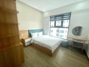 ニャチャンにあるRoyal Nha Trang Luxury Apartmentのベッドと大きな窓のある寝室