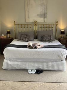 a large bed with a dog laying on it at The King Suite at Mill Cottage in Garden Island Creek